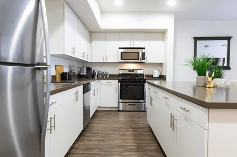 a kitchen with white cabinets and stainless steel appliances